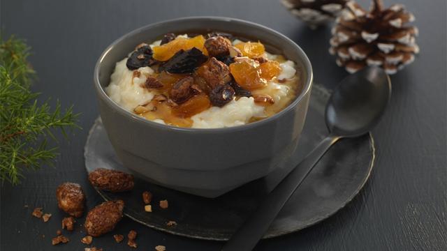 Varm risgrøt toppet med aprikos, rosiner, svisker, ristede nøtter og lønnesirup.